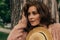 Portrait of a beautiful girl who stands near a tree. summer, walk in nature, red-haired girl in a vintage dress and a beige sweate