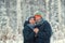 Portrait of a beautiful happy couples in winter forest. Husband and wife smiling.