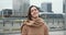 Portrait of beautiful happy healthy elegant business woman in beige coat looking at camera smiling in city background.