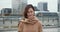 Portrait of beautiful happy healthy elegant business woman in beige coat looking at camera smiling in city background.