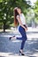 Portrait of beautiful happy stylish woman with long hair in high heels shoes, walking in city park. Woman style, trendy outfit.