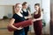 Portrait of beautiful happy yogi girl with pink hair holding folded red yoga mat after training lesson in fitness center or gym, h