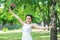 Portrait of a beautiful happy young female bride with small wedding pink flower roses bouquet smiling raising arms at sunny summer