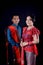 Portrait of beautiful indonesian couple wearing traditional batak costume isolated on black background