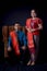 Portrait of beautiful indonesian couple wearing traditional batak costume sit on brown couch isolated on black background
