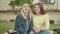 Portrait of beautiful joyful female students pointing away and laughing. Front view of two young Caucasian women talking