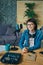 Portrait of beautiful lady blogger sitting at table in recording studio smiling