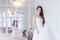 Portrait of beautiful laughing bride. Wedding dress with open back. Luxurious light interior