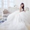 Portrait of beautiful laughing bride. Wedding dress with open back. Luxurious light interior