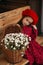 Portrait of a beautiful little girl with  flowers in autumn gazebo