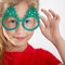 Portrait of a beautiful little girl with glasses. Christmas accessory. Face close up