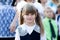 Portrait of a beautiful little girl in a school dress and in bows. First grade