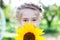 Portrait of a beautiful little girl with a sunflower. concept of childhood, health and lifestyle. child is hiding behind a flower.