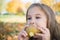 Portrait of a beautiful little girl who eats a pear on a picnic in the autumn park