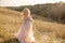 Portrait of a beautiful little princess girl in a pink dress. Posing in a field at sunset