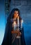 Portrait beautiful medieval queen woman. Girl holding white vintage old burning candles, candlestick. Blue silk royal