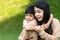 Portrait beautiful mother and child happily hugged in park. Asian family mom and child are hugging and looking at the camera, cute