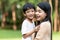 Portrait beautiful mother and child happily hugged in park. Asian family mom and child are hugging and looking at the camera, cute