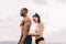 Portrait of beautiful muscular mixed race couple with perfect bodies in sportswear softly embracing on mountains