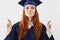 Portrait of beautiful yet nervous redhead graduate girl in mantle praying to success as future lawyer or doctor fingers