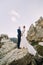 Portrait of beautiful newlywed couple on majestic mountain landscape with massive rocks as backround