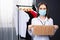 Portrait of a beautiful owner of a clothing store with a sign, placard Reopened, Open. Saleswoman wears a protective mask in