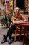 Portrait of beautiful pensive woman grins, eyes glistening, young Caucasian female person at cafe, blonde girl looking away, beige