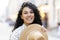 Portrait of a beautiful playful Latin American woman, a young tourist walking through the city in the evening, smiling