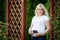 Portrait of beautiful pregnant woman in the flowering park. Young happy pregnant woman holds an ultrasonography photo