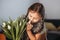 Portrait of beautiful pretty girl with white flowers tulips. Indoor photo