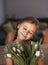 Portrait of beautiful pretty girl with white flowers tulips. Indoor photo