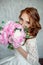 Portrait of beautiful red-haired girl holding bouquet.