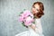 Portrait of beautiful red-haired girl holding bouquet.