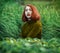 Portrait of beautiful redhaired girl in tall grass in a warm sw