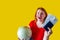Portrait of beautiful redhead girl with globe on yellow background