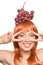 Portrait of beautiful redhead young woman with red grapes on head showing peace signs