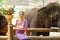 Portrait of Beautiful rural thai woman wear Thai northern traditional dress acting for phot shoot with Asian elephant on blurred