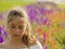 Portrait of a beautiful sad teenage girl on a blurry floral background. Close up of a girl`s face illuminated from above by the
