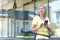 Portrait of a beautiful senior woman. Stands with a yellow bicycle near the office center, uses the phone. Gets a message. He`s