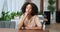 Portrait of beautiful sensual pensive millennial girl afro american woman with curly hairstyle sitting at table in cafe