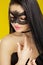 Portrait of beautiful sensual woman in black lace mask on yellow background. girl in venetian mask