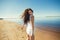 Portrait of beautiful sexy happy girl on the sand city beach with sea background. Young smiling woman having fun