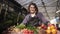 Portrait of beautiful, shorthaired, smiling woman farmer selling organic food in farm market smiling looking at camera