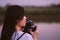 Portrait of beautiful smile asian woman with holding medium format film camera with green nature background