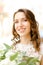 Portrait of beautiful smiling bride keeping flowers.