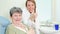 Portrait of beautiful smiling dentist and elderly woman giving thumbs up