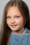 Portrait of a beautiful smiling girl with blue eyes, with light brown hair. She looks into the camera. Family concept