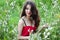 Portrait of beautiful smiling woman in red dress in flower field