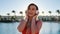 Portrait of beautiful smilling woman in red swimsuit and headphones, dancing and listening music on smartphone using app