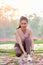 Portrait of beautiful sport girl is tiring shoelace on bricks and pink flower spread to the floor in the garden with morning light